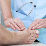 A doctor is examining someone 's foot.