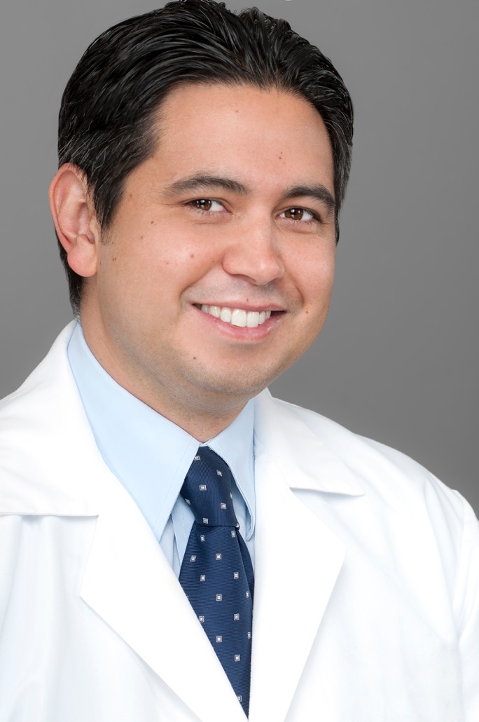 A man in white lab coat and tie.