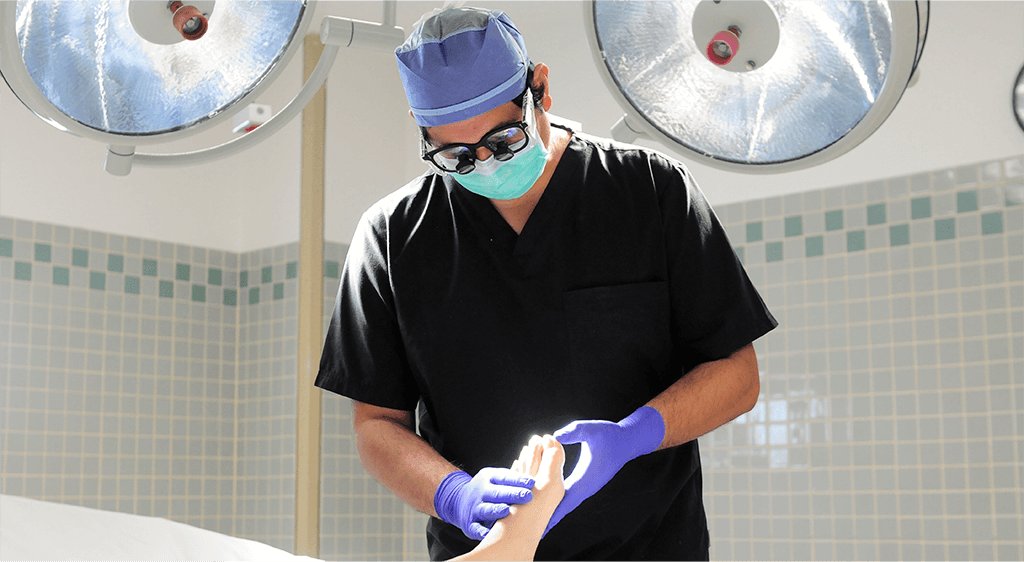 A surgeon wearing surgical gloves and mask